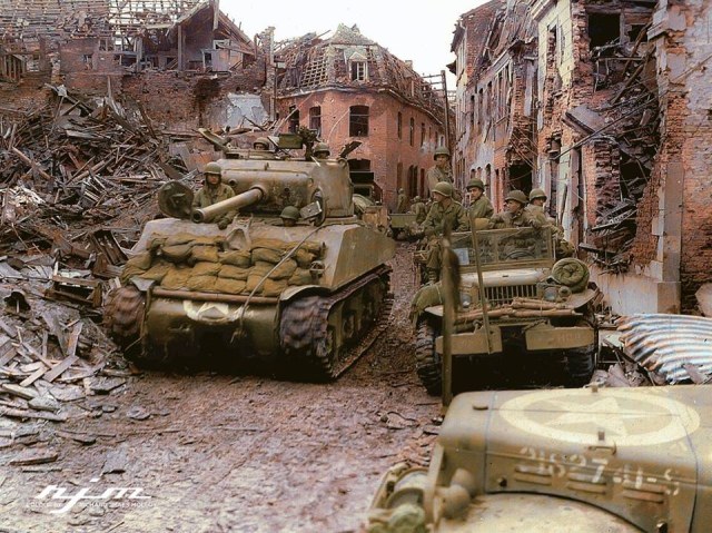 руины Американский средний танк M4A3(76)W из состава 771-го танкового батальона продвигается по улице немецкого города Линних, 24 февраля 1945 года. Батальон поддерживал наступление 84-й пехотной дивизии..jpg