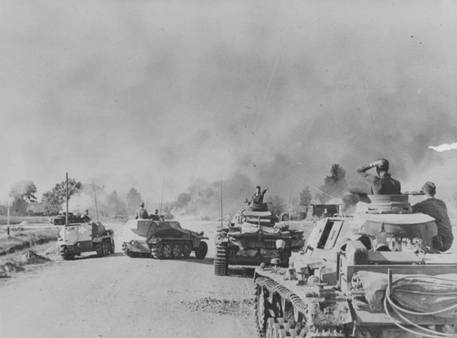 Немецкая м.пехота при поддержке т-ов 1-й т.див. ведет бой за д.Соловьи Псковской обл. На снимке легкие бтры Sd.Kfz.250-1, средний танк Sd.Kpfw.III Ausf. G. раннего выпуска и командирский танк Pz.Bfw. III Ausf.E.jpg
